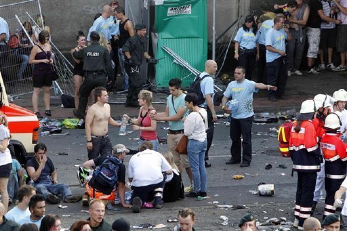 Collapsed people get first aid after a panic on this year's techno-music festival "Loveparade 2010" in Duisburg, Germany, on Saturday, July 24, 2010. German police say that 10 people were killed and 15 others injured when mass panic broke out in a tunnel at the Love Parade. (AP Photo/dapd/Hermann J. Knippertz)