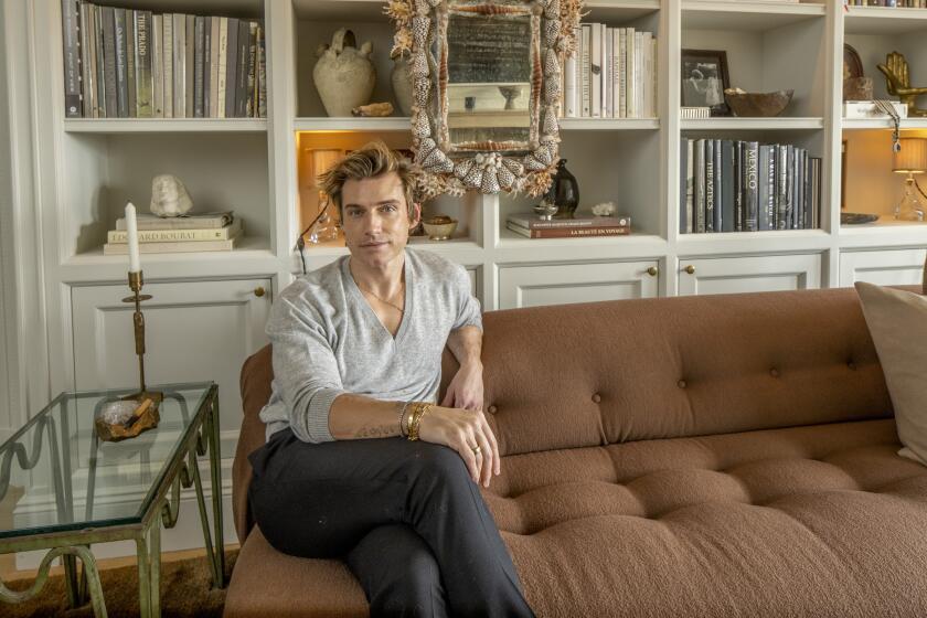 Interior designer Jeremiah Brent sits on a couch at his home in New York.