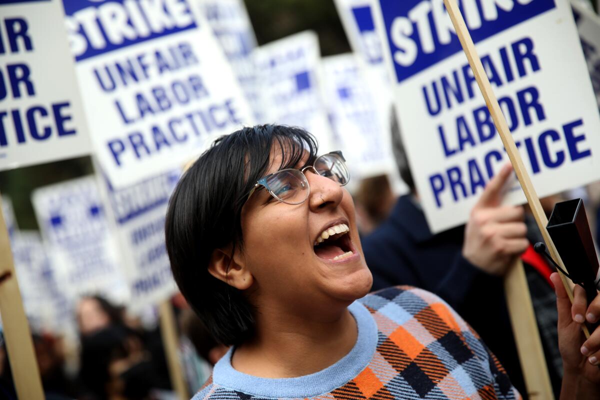 A woman shouts while walking a picket line