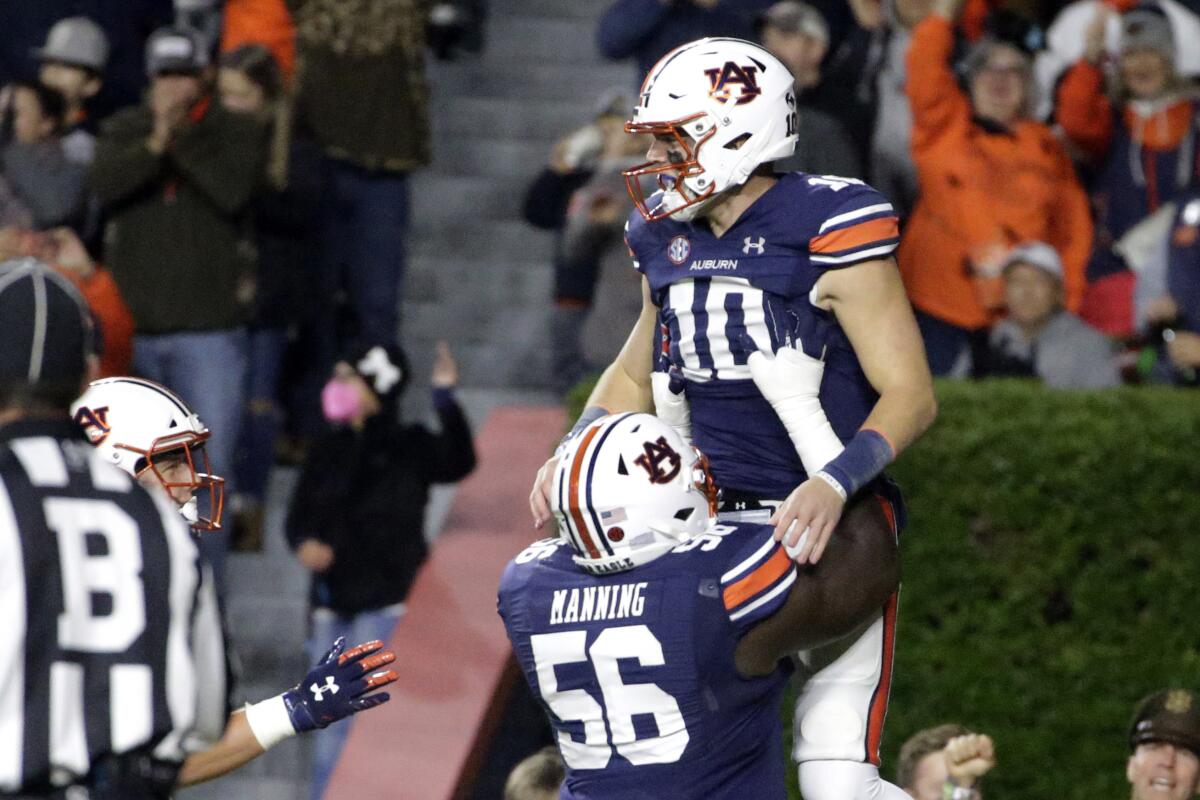 Auburn quarterback Bo Nix (10) gets a lift from offensive lineman Tashawn Manning after scoring a touchdown Oct. 30, 2021.