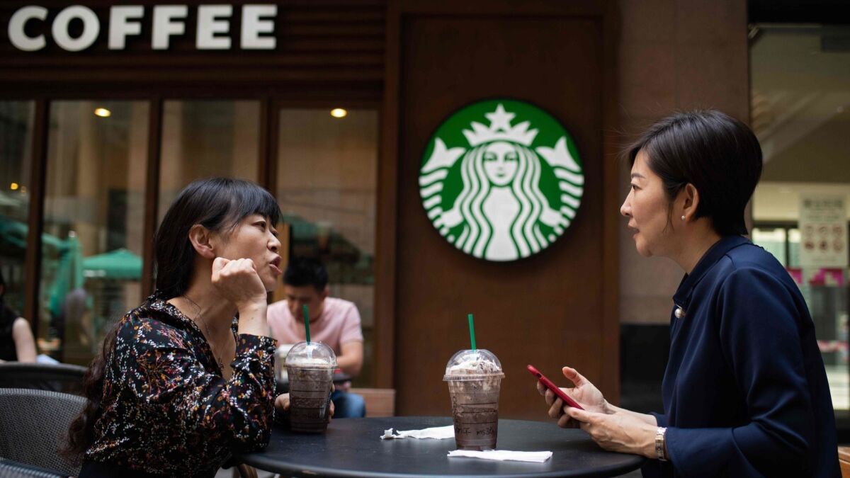 Women talk at a Starbucks coffee shop in Beijing. Starbucks wants to more than triple its revenue from China over the next five years.
