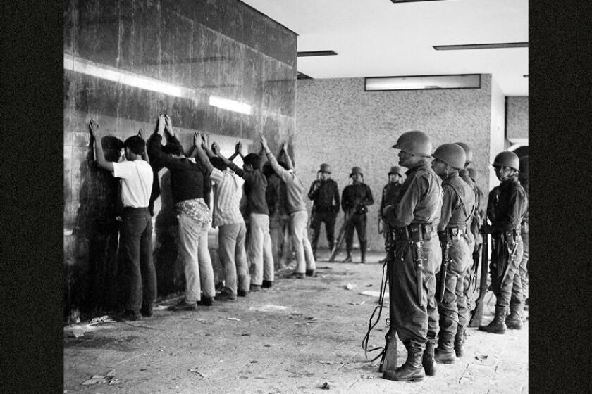 Mexican soldiers guard a group of young men rounded up after the night that came to be known as the "Tlatelolco massacre" 