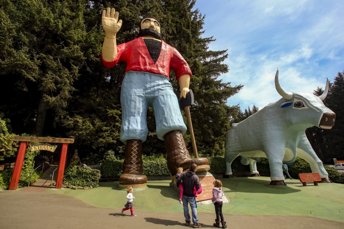 Towering Paul Bunyan, beside his blue ox, Babe, waves at a family below.