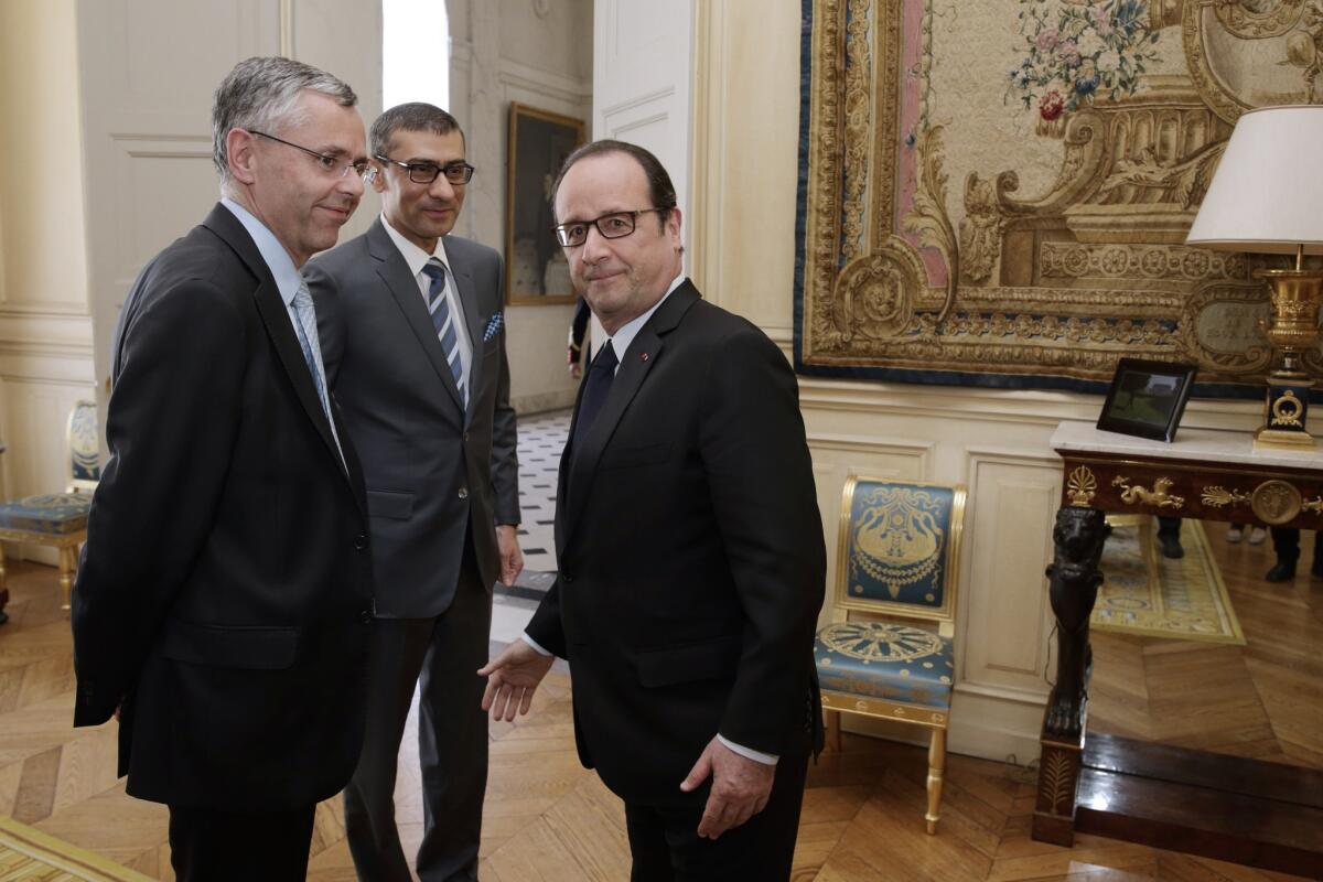 French President Francois Hollande, right, meets with Alcatel-Lucent CEO Michel Combes, left, and Nokia CEO Rajeev Suri at the Elysee Palace in Paris on April 14.