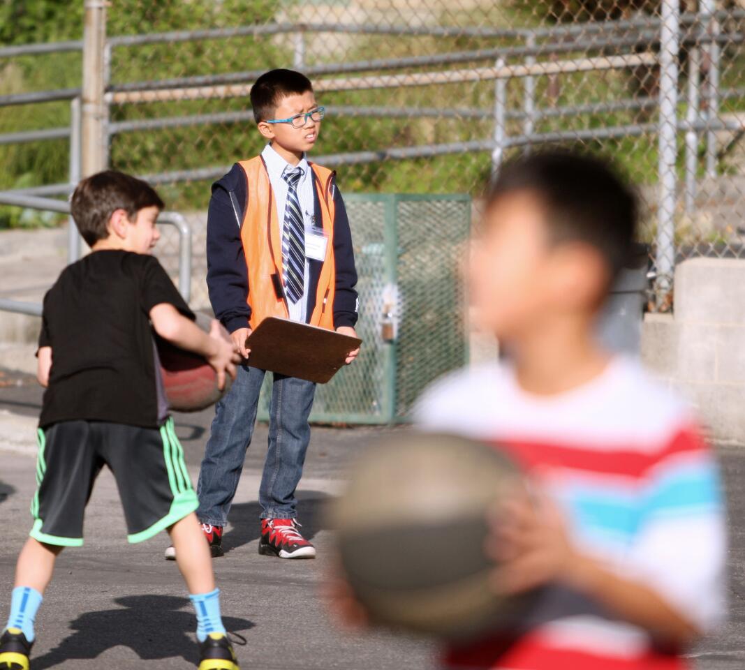 La Cañada Elementary School fifth-grader and "Principal for a Day" Michael Kwan, center, keeps an eye on the action during recess.