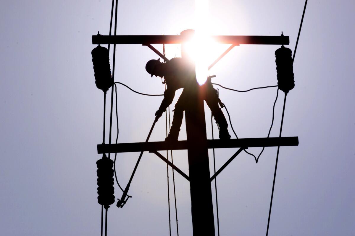 A Southern California Edison lineman grounds a power line in La Habra.