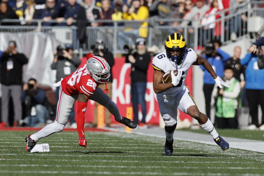 Michigan receiver Cornelius Johnson, right, turns up field to score a touchdown past Ohio State defensive back Cameron Brown during the first half of an NCAA college football game on Saturday, Nov. 26, 2022, in Columbus, Ohio. (AP Photo/Jay LaPrete)