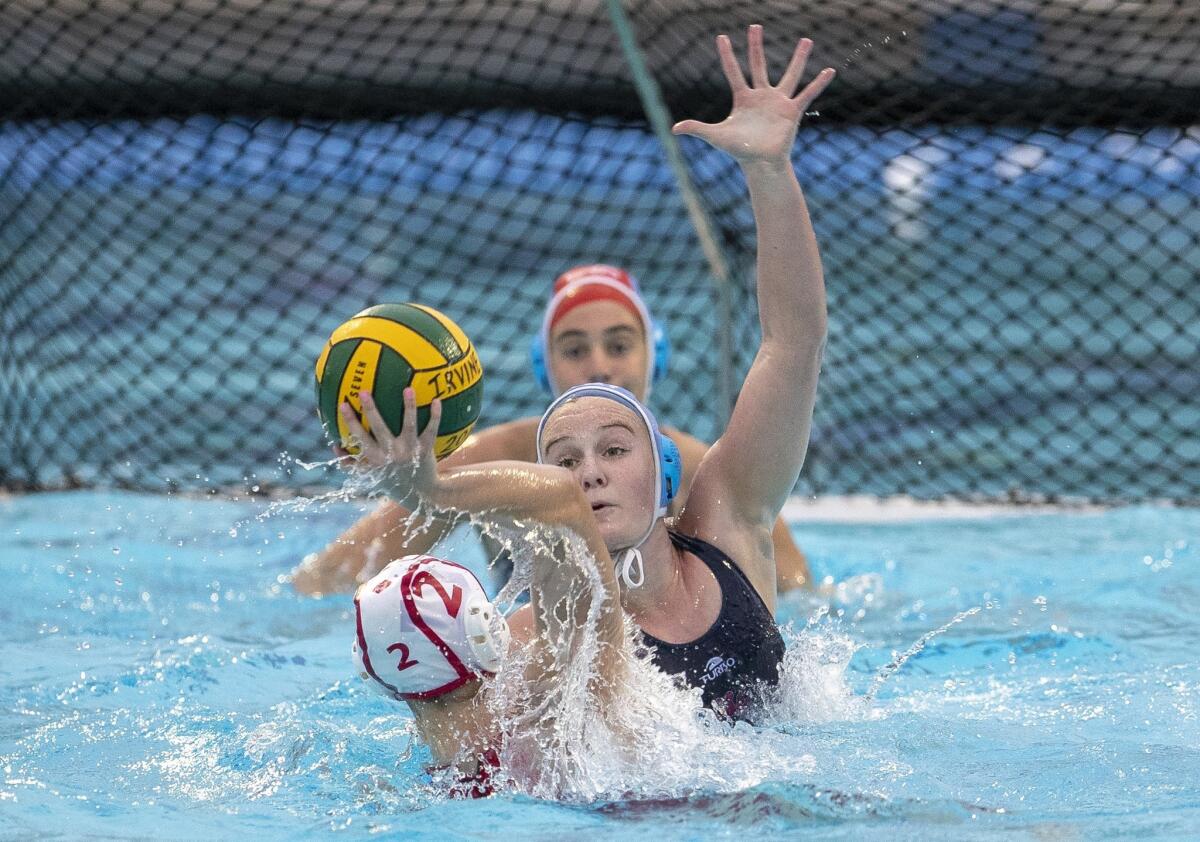 Corona del Mar's Sophie Wallace attempts to block a shot by Orange Lutheran's Delaney Demsher in the CIF Southern Section Division 1 semifinal playoff match on Feb. 13 at Irvine’s Woollett Aquatics Center.