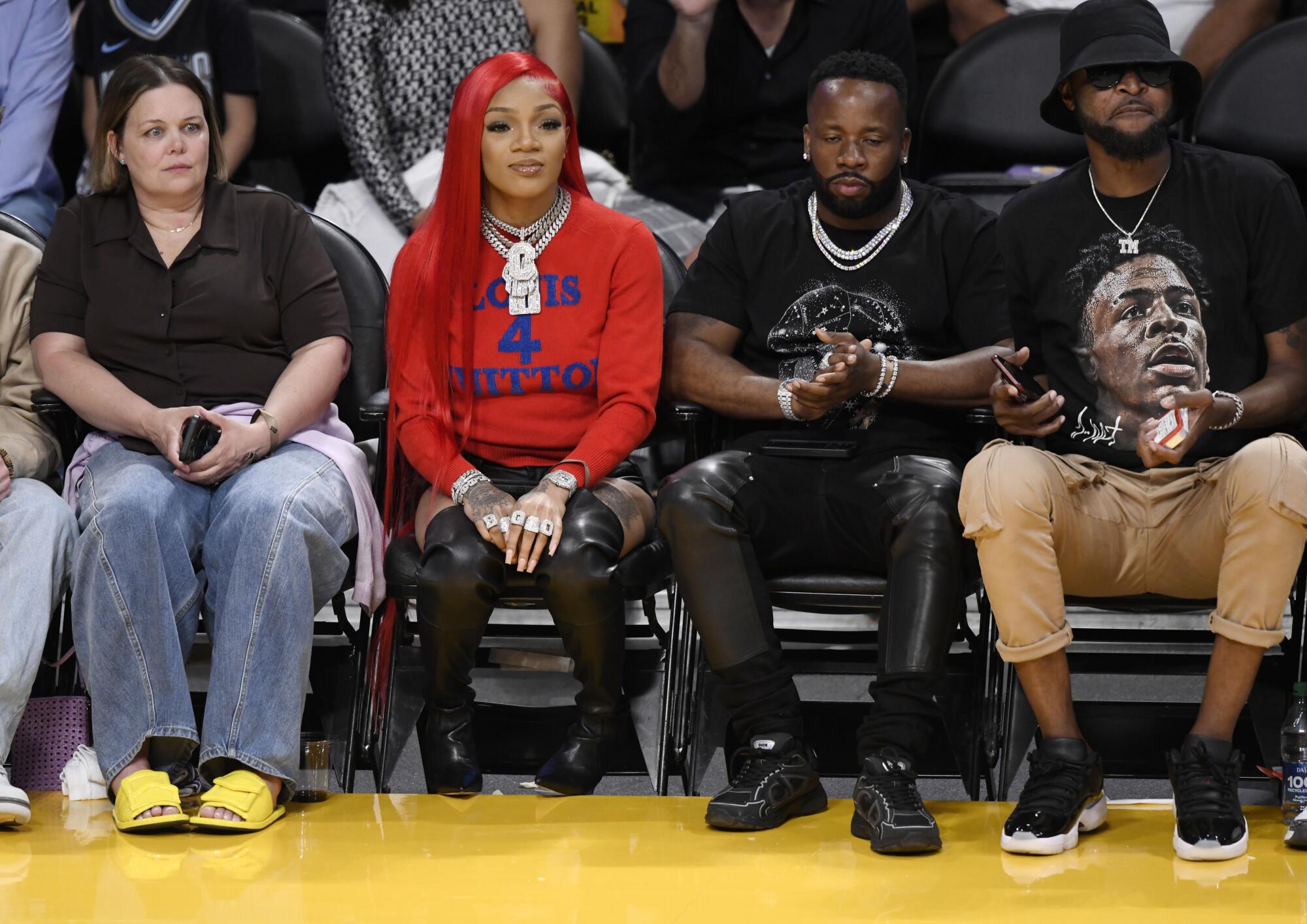 Rapper GloRilla, second from left, attends a basketball game.