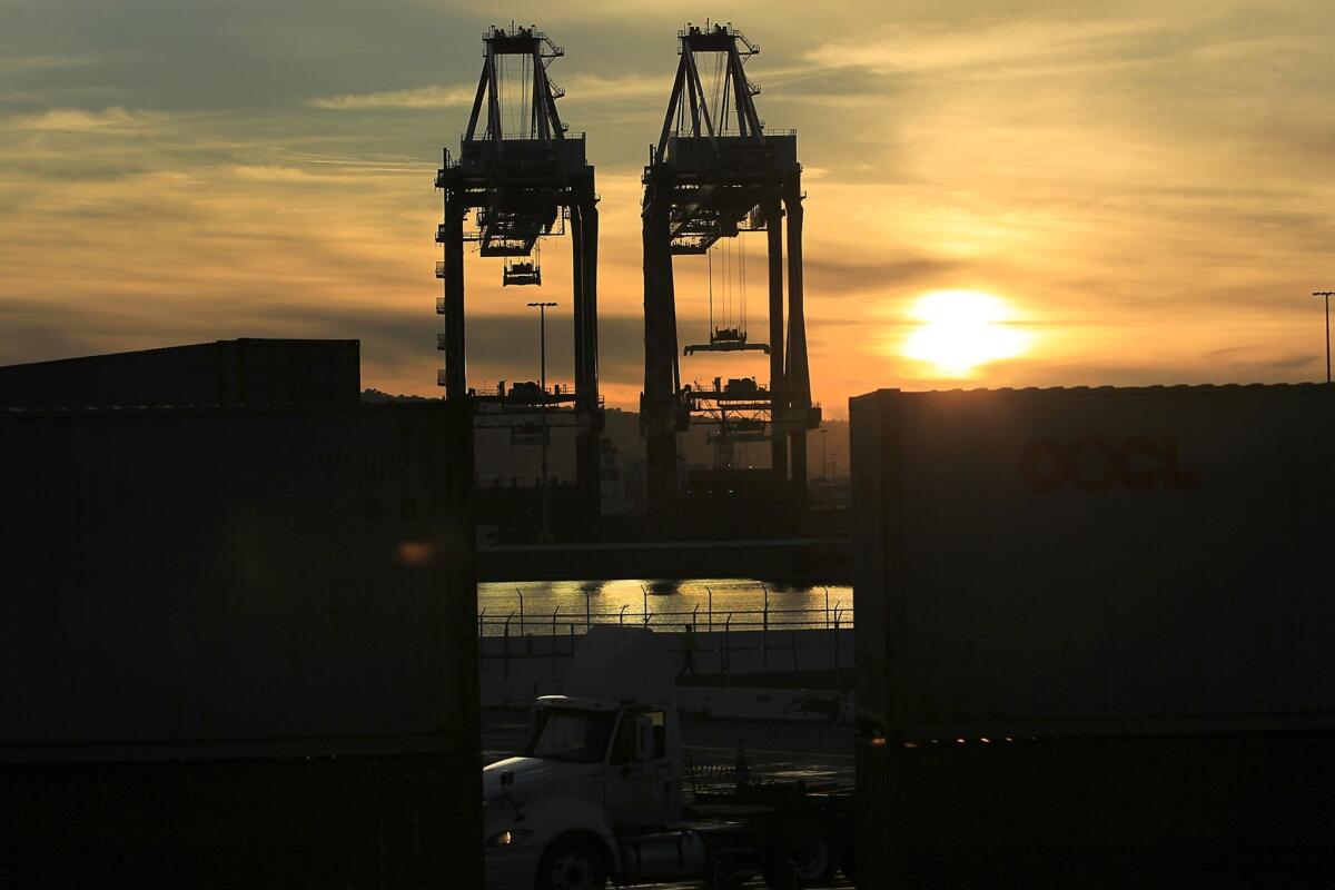 The L.A. 2020 Commission recommends that the ports of Los Angeles and Long Beach merge to better compete with other ports. Above, container cranes are silhouetted in the evening sky at the port of Los Angeles on Tuesday.