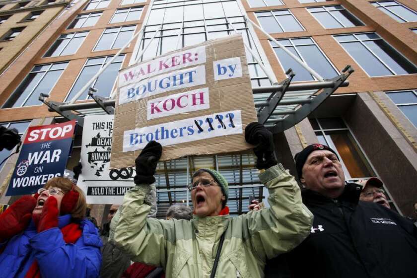 Jane Pederson, center, of Menomonie, Wis., protests in front of the offices of Koch Industries in Madison, Wis., in 2011.