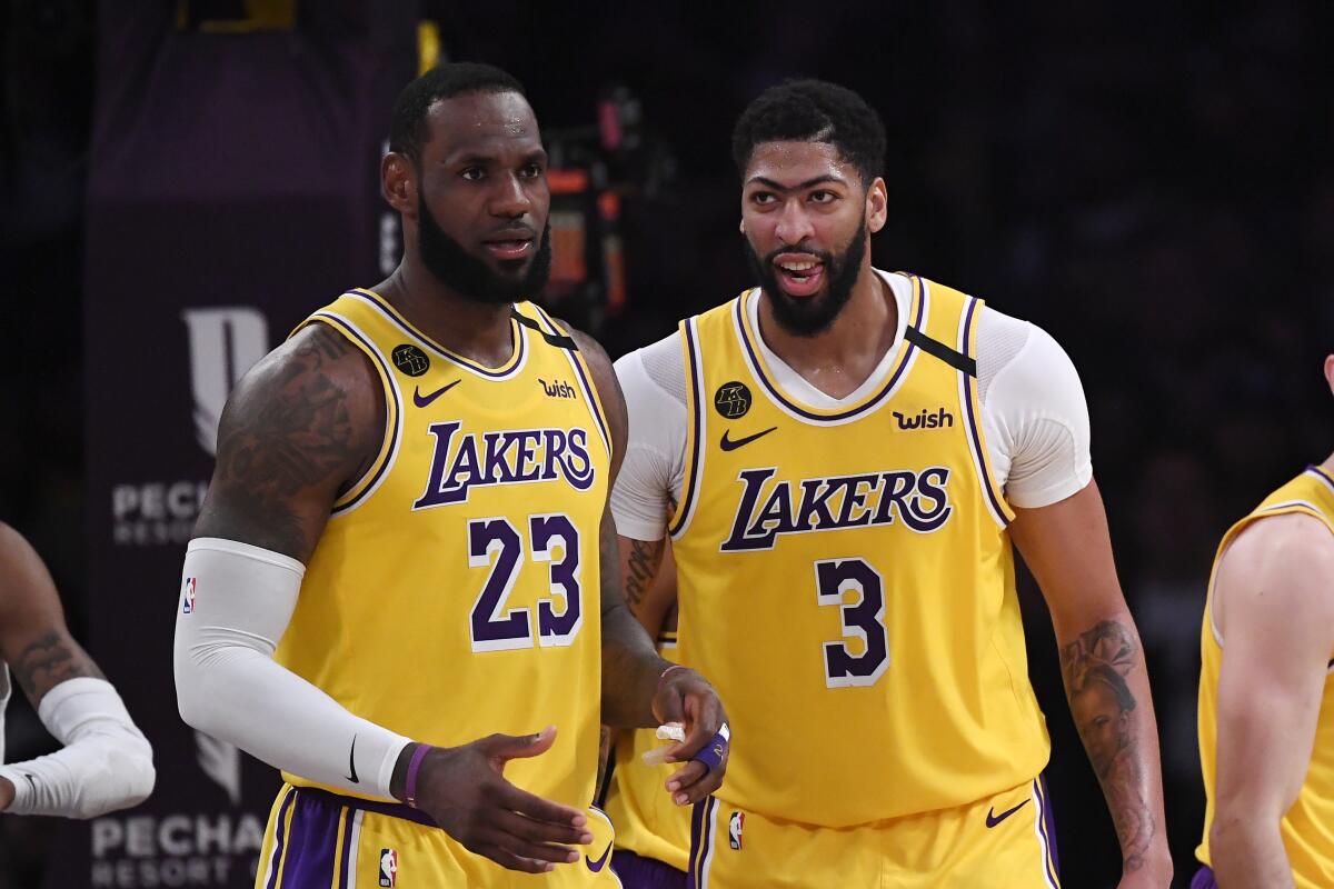 Lakers forward LeBron James, left, stands with forward Anthony Davis during a game Feb. 21, 2020