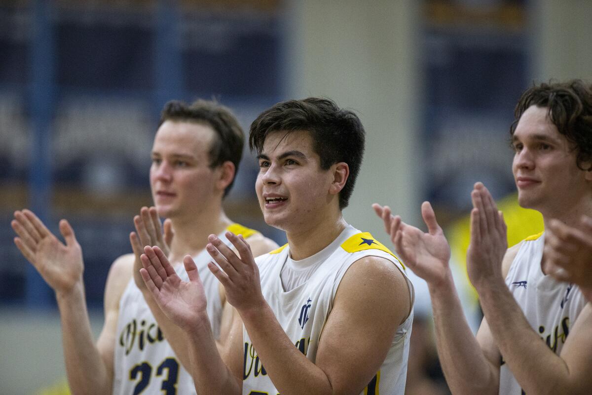 Marina's Robert Aguirre, center, cheers for his teammates during Friday night's game.
