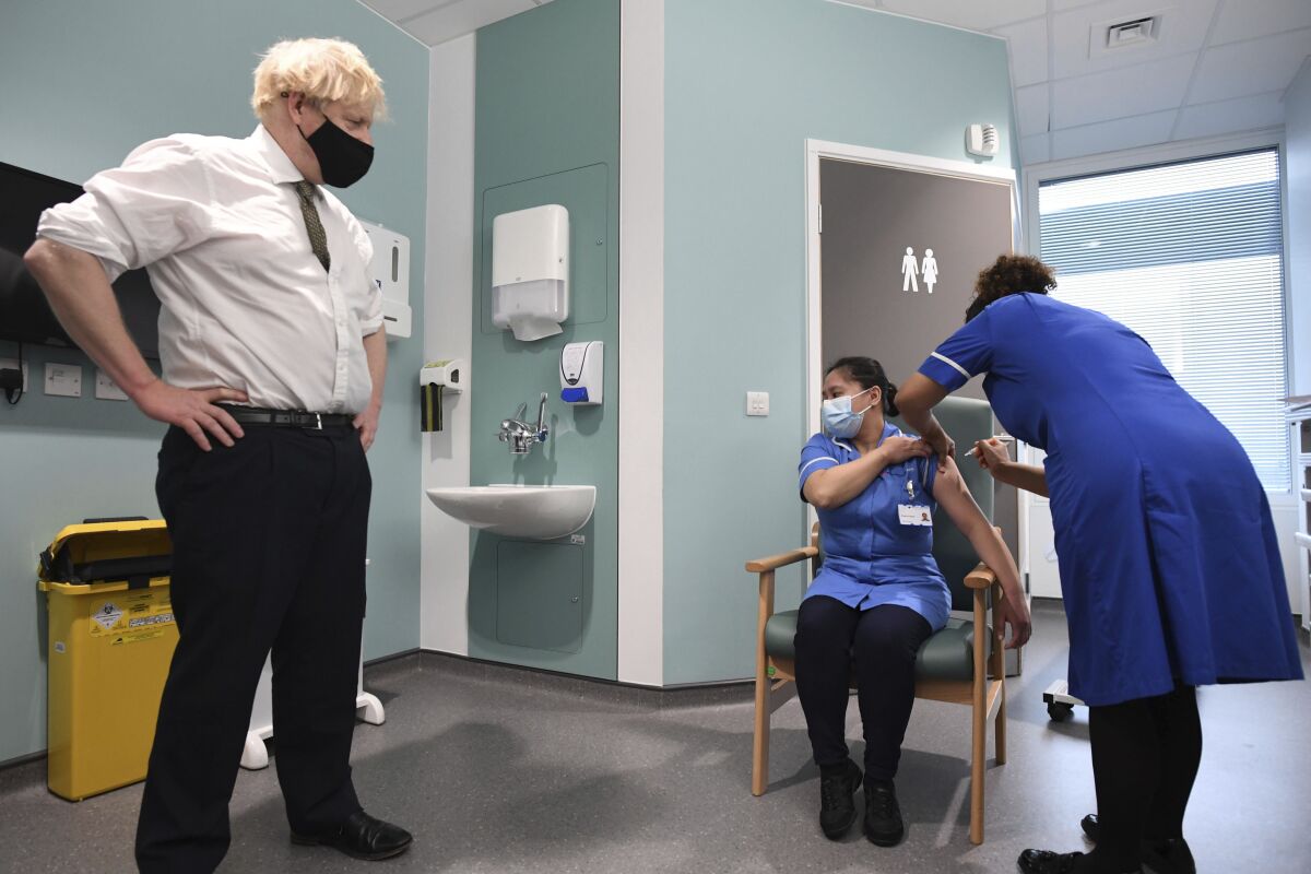 Boris Johnson watches as nurse Jennifer Dumasi is injected with the Oxford-AstraZeneca Covid-19 vaccine