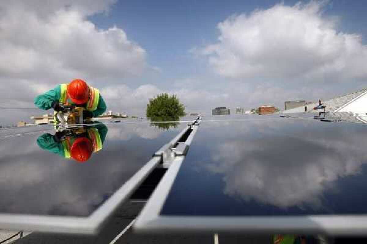 SolarCity installer Victor Zapata uses a ban saw to make cuts while assembling thin film technology solar panels in Los Angeles. SolarCity said Monday that it is planning an IPO.