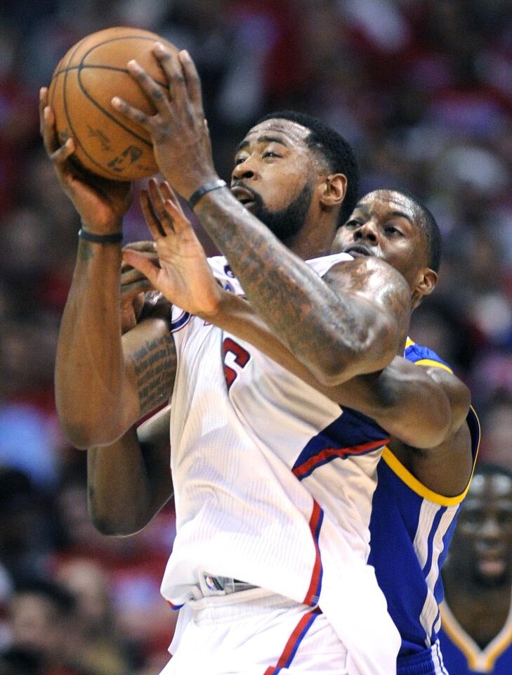 Clippers center DeAndre Jordan, left, is fouled by Golden State Warriors small forward Harrison Barnes while catching a pass during the Clippers' 138-98 win in Game 2 of the Western Conference quarterfinals at Staples Center.