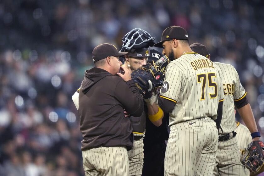 San Diego Padres pitching coach Ruben Niebla, left, talks with relief pitcher Robert Suarez and catcher Brett Sullivan during the eighth inning of the team's baseball game against the Chicago White Sox on Friday, Sept. 29, 2023, in Chicago. (AP Photo/Charles Rex Arbogast)