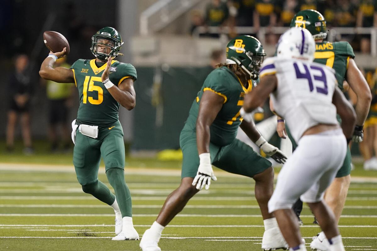 Baylor quarterback Kyron Drones (15) throws a pass with blocking from offensive lineman Kaden Sieracki (74) against Albany linebacker Jackson Ambush (43) during the second half of an NCAA college football game in Waco, Texas, Saturday, Sept. 3, 2022. (AP Photo/LM Otero)