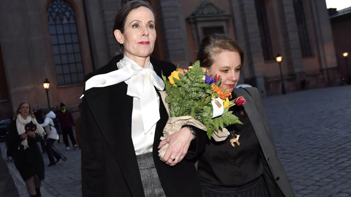 Swedish Academy leader Sara Danius, left, wearing a signature pussy-bow blouse, and academy member Sara Stridsberg leave a meeting in early April. Danius was later forced out.