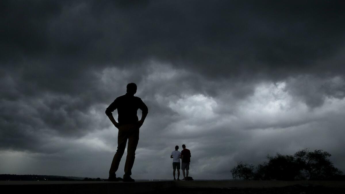 People in downtown Kansas City, Mo., watch a storm approach.
