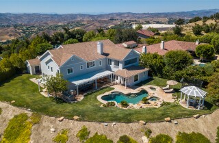 The estate spans half an acre in the guard-gated Oaks of Calabasas neighborhood and centers on a 6,000-square-foot custom home.