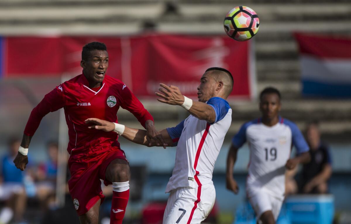 Bobby Wood of the U.S., center, heads the ball against Cuba´s David Urgelles on Oct. 7.