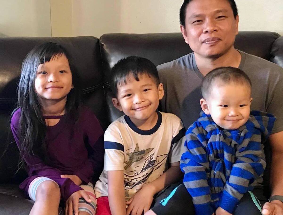 This undated photo provided by Bawi Cung, shows Bawi Cung, right, seated with his children at home, before he and his two sons were stabbed in an anti-Asian attack last March 2020 at Sam's Club in Midland, Texas. Asian Americans have been facing a dangerous climate since the coronavirus entered the U.S. a year ago. A rash of crimes victimizing elderly Asian Americans in the last two months has renewed outcry for more attention from politicians and the media. (Bawi Cung via AP)