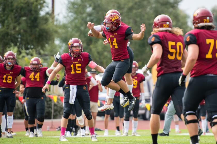 Harvey Mudd College kicker Alessandro Maiuolo jumps in the air and celebrates with teammates after a 54-yard field goal.