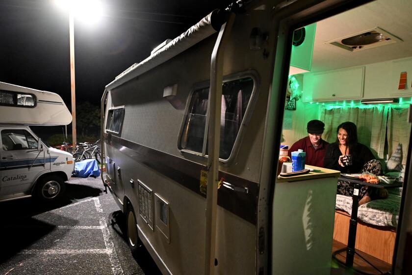 Arcata, California November 17, 2023-Students Brad Butterfield and Maddy Montiel study in a camper parked on the Cal Poly Humboldt campus. The university recently issued an eviction notice for students who sleep in their vehicles. (Wally Skalij/Los Angeles Times)