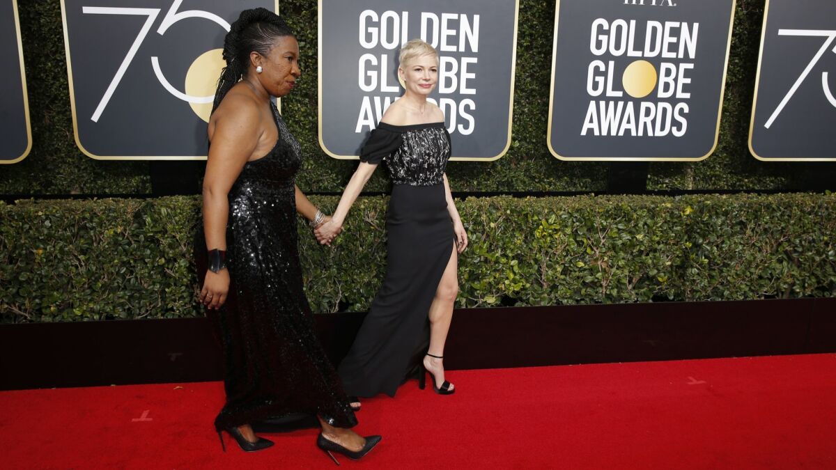 Michelle Williams, right, walks the 2018 Golden Globes red carpet with Tarana Burke, who sparked the #MeToo movement.