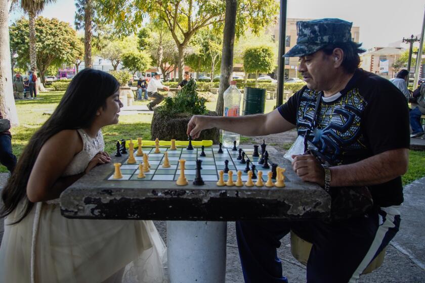 Tijuana, Baja California - April 10: With the warm weather children playing at the city park Teniente Guerrero. Gena Diaz 10 years-old plays chess with her father Andres Diaz 55 in Downtown on Wednesday, April 10, 2024 in Tijuana, Baja California. (Alejandro Tamayo / The San Diego Union-Tribune)