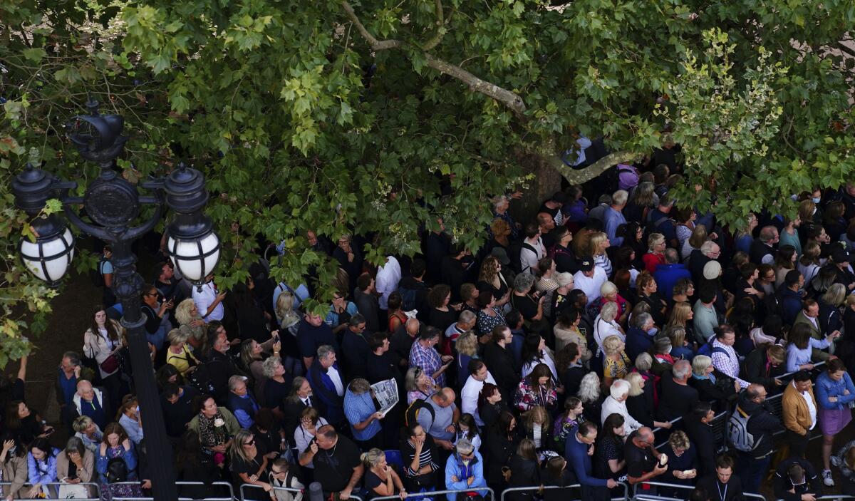 Crowds waiting to see procession of Queen Elizabeth II's coffin from Buckingham Palace to Westminster Hall