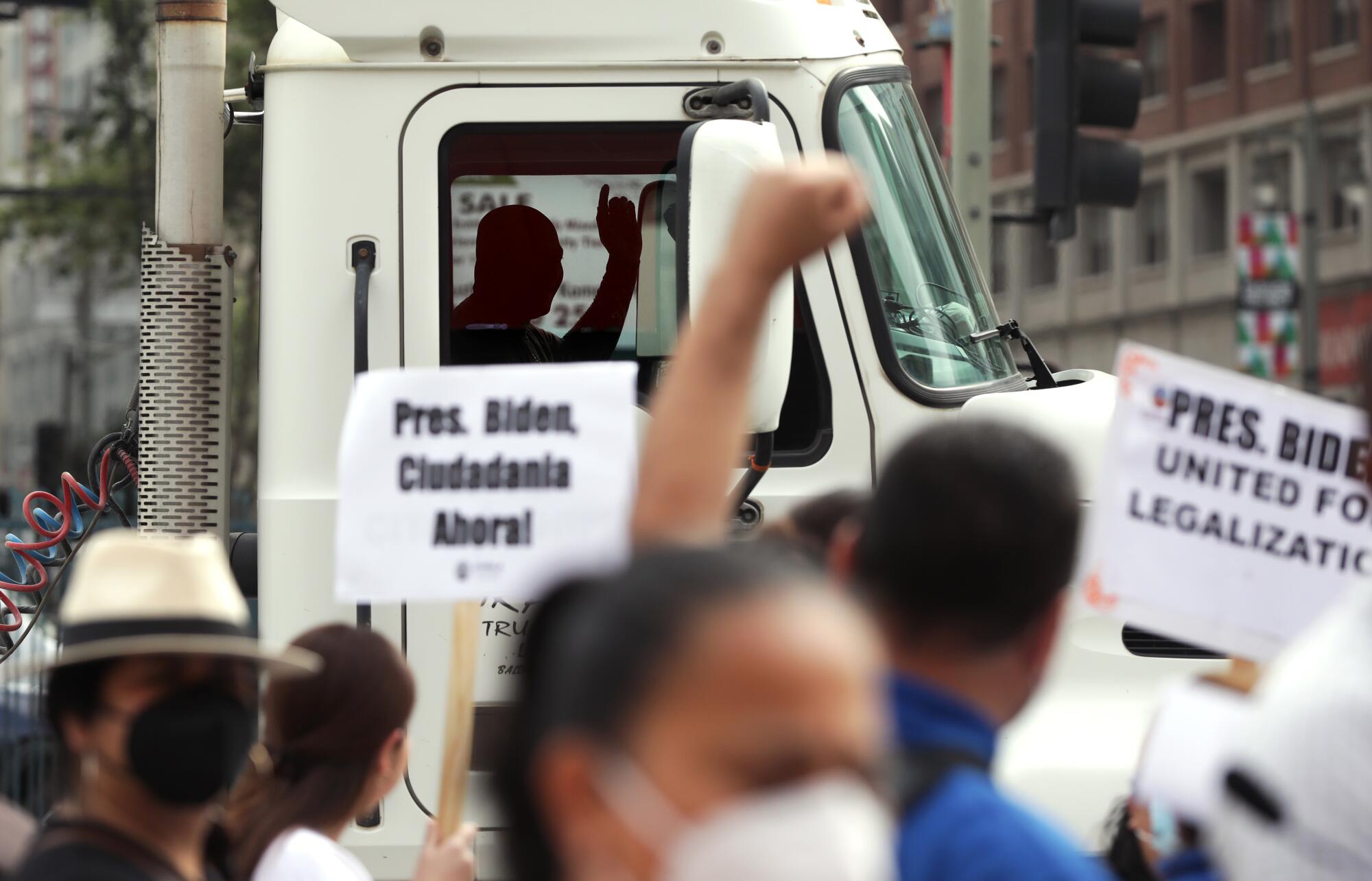 A truck driver honks his horn in support during a Migration and Human Rights for the Americas rally