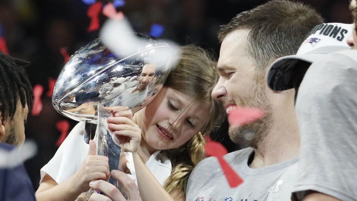New England quarterback Tom Brady shares a moment with his 6-year-old daughter, Vivian Lake, after the Patriots won the Super Bowl 13-3 over the Los Angeles Rams on Sunday in Atlanta.