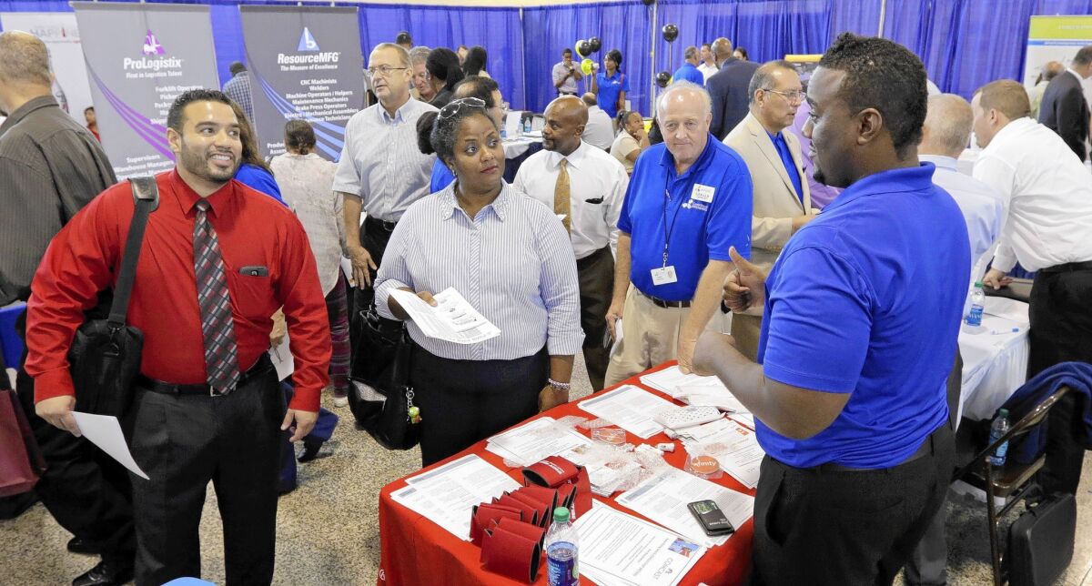 Job seekers attend a hiring fair for veterans in Fort Lauderdale, Fla. Although the U.S. economy this year recovered all of the jobs lost during the recession, the new jobs are largely in lower-wage industries such as hospitality and healthcare, a new analysis says.