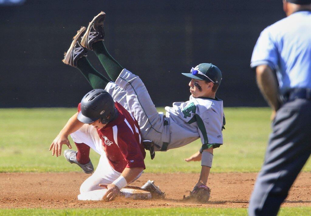 Costa Mesa High's Grady Conner trips over Estancia's Jackson Letterman after losing control of the ball at second base during the first inning on Wednesday.