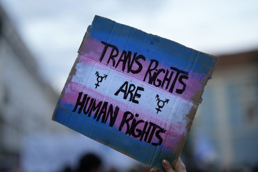 FILE - A demonstrator holds up a sign during a march to mark International Transgender Day of Visibility in Lisbon, March 31, 2022. At least 32 transgender and gender-nonconforming people have been killed in the United States in 2022, the Human Rights Campaign announced Wednesday, Nov. 16, in its annual report ahead of Transgender Day of Remembrance on Sunday, Nov. 20. (AP Photo/Armando Franca, File)