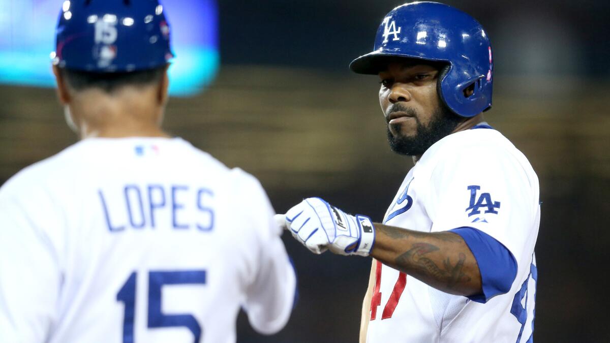 Dodgers second baseman Howie Kendrick is congratulated by first base coach Davey Lopes after hitting a two-run single against the Athletics on July 29.