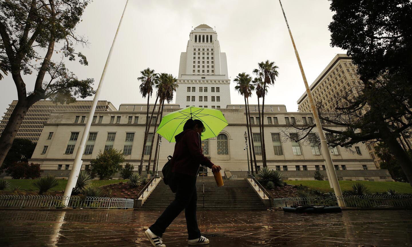 Isabelle Torres makes her way through rain and hail in downtown Los Angeles, Wednesday .