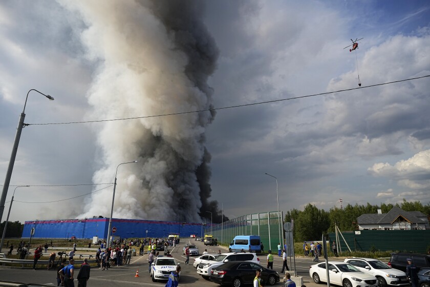 Smoke rises over a burning warehouse of the online retailer Ozon in Istra Municipal District, northwest Moscow Region, Russia, Wednesday, Aug. 3, 2022. The fire, which erupted at the warehouse belonging to Russia's leading online retailer Ozon, has covered the area of 50,000 square meters and injured 11 people, two of whom were hospitalized. (AP Photo/Alexander Zemlianichenko)