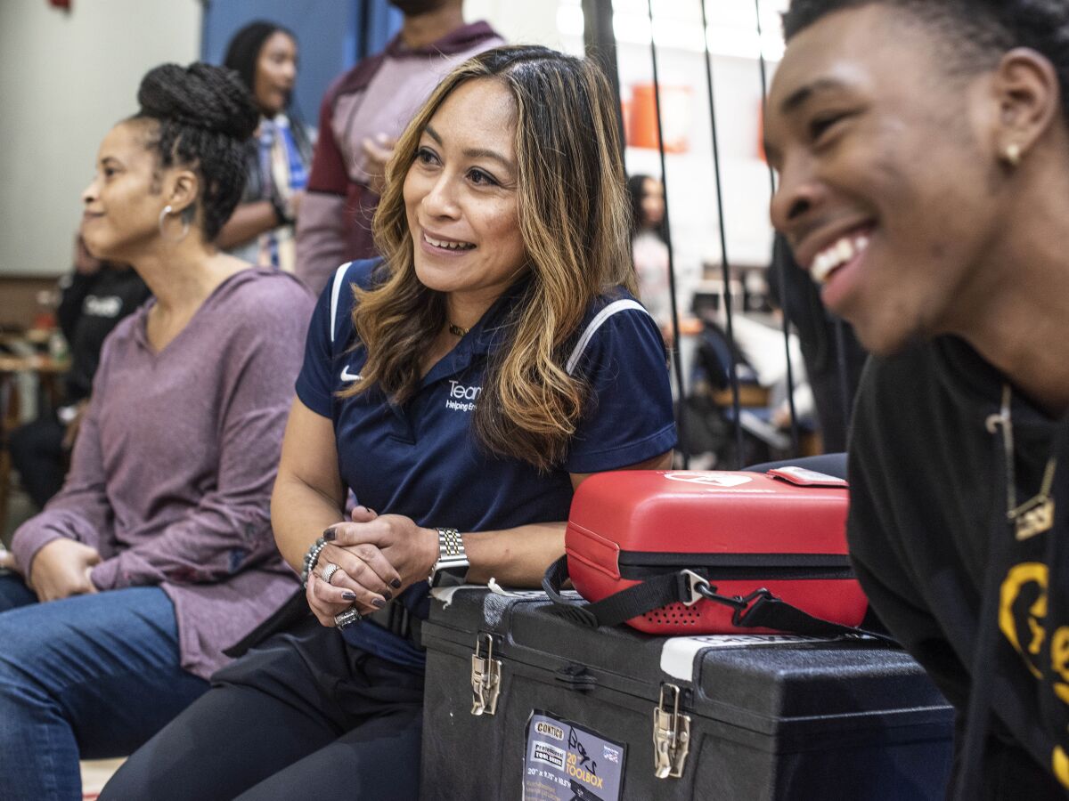 Crenshaw athletic trainer Ellen Kelly, watching the Cougars play a basketball game Friday, helped save the life of coach Ed Waters earlier this month when he collapsed along the sideline.