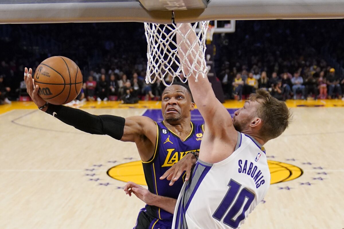 Lakers guard Russell Westbrook, left, shoots in front of Sacramento Kings forward Domantas Sabonis.