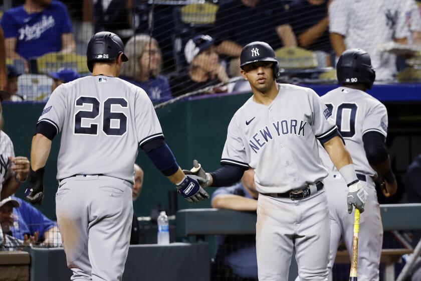 New York Yankees' Oswald Peraza, center, congratulates DJ LeMahieu (26) and Estevan Florial, right, after they scored off a single by Gleyber Torres during the sixth inning of a baseball game against the Kansas City Royals in Kansas City, Mo., Saturday, Sept. 30, 2023. (AP Photo/Colin E. Braley)