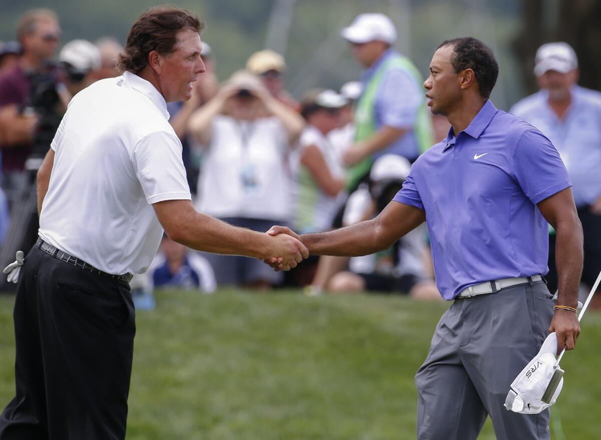 Phil Mickelson and Tiger Woods shake hands during the first-round of the PGA Championship at Valhalla in Louisville. Mickelson finished with a two-under par 69 on Thursday while Woods shot a three-over 74.