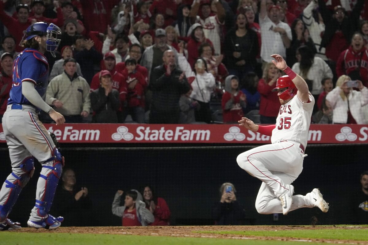 Chad Wallach scores as Texas catcher Jonah Heim stands at the plate