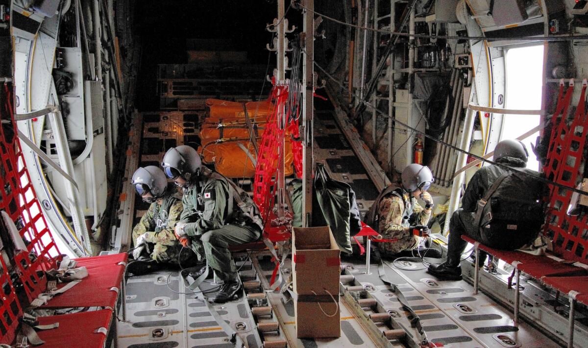 Japanese Air Self-Defense Force crew members aboard a C-130 scan the southern search area in the southeastern Indian Ocean south of Sumatra, Indonesia, Friday, March 21, 2014.