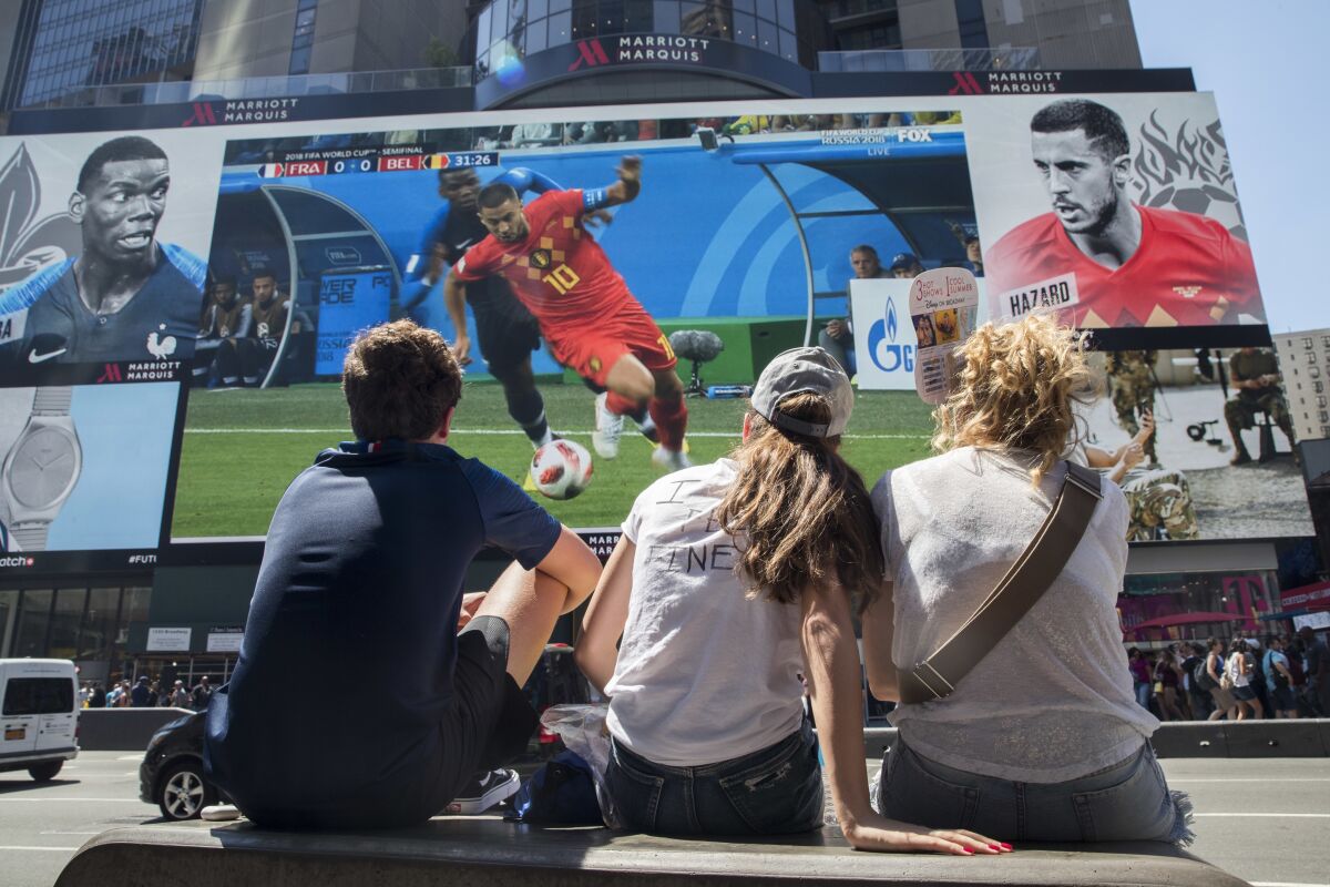 FILE - French soccer fans watch France play Belgium in a World Cup semifinal soccer game on a gigantic screen in New York's Times Square, on July 10, 2018, in New York. U.S. cities and states have lined up with tax breaks and millions of dollars in both public and private investments for a chance at hosting 2026 FIFA World Cup games, set to be announced Thursday, June 16, 2022. (AP Photo/Mary Altaffer, File)