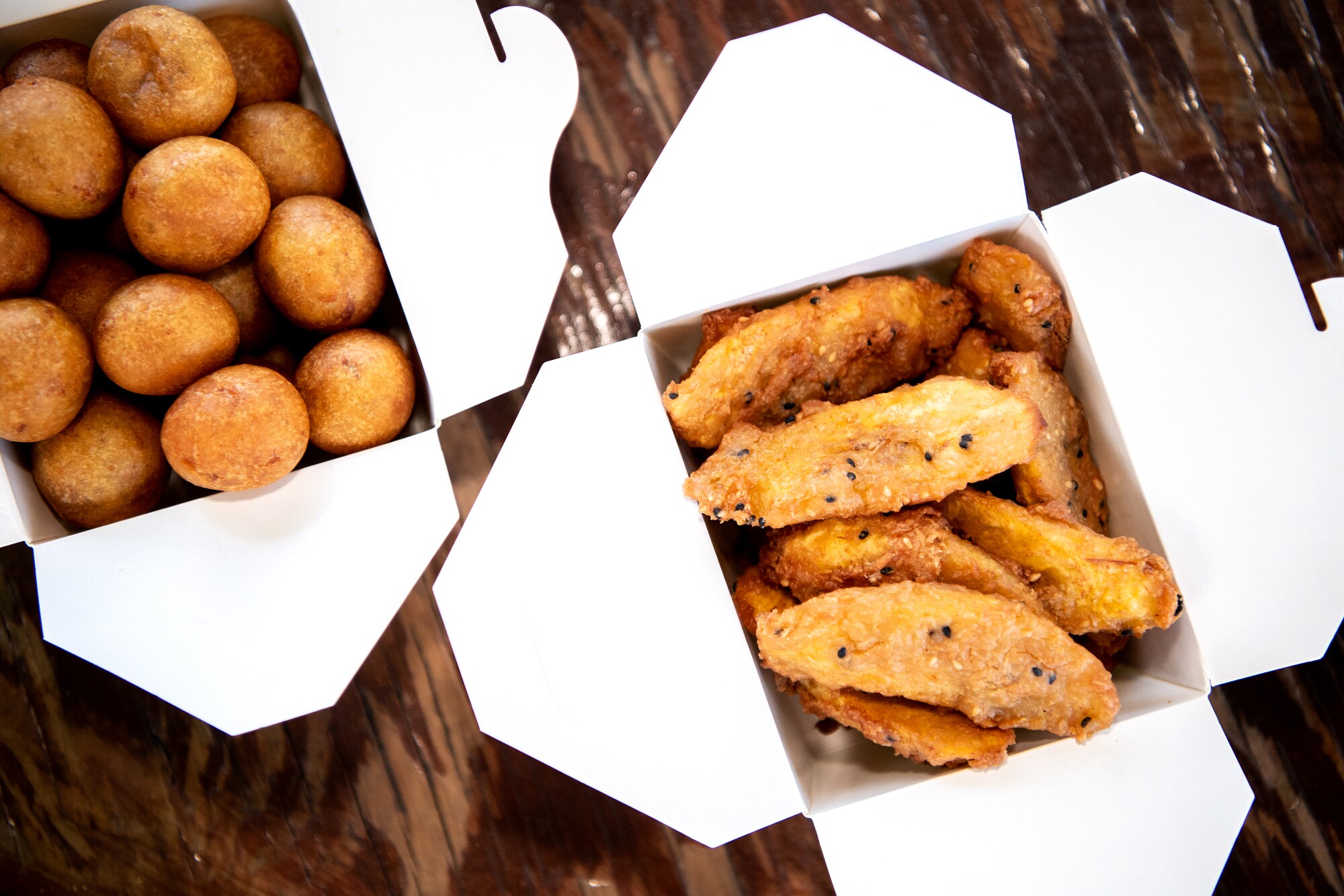 The cardboard boxes contain two kinds of fried desserts.