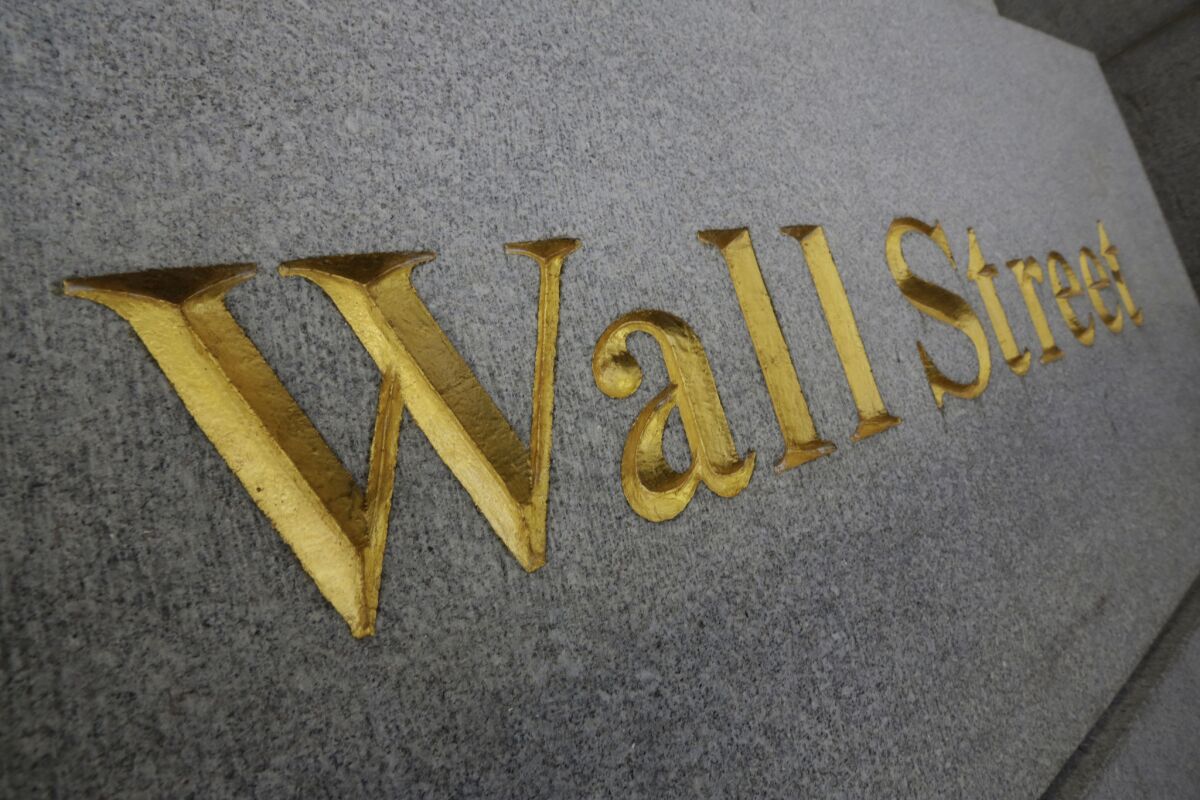 A gold-lettered Wall Street sign on a gray wall in New York
