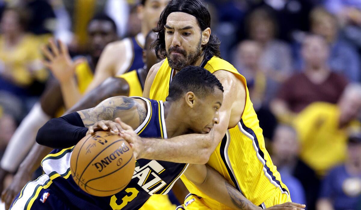 Pacers forward Luis Scola knocks the ball away from Jazz guard Trey Burke during the second half of their game Monday night in Indianapolis.